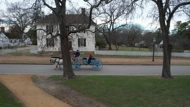Drone footage of a blue carriage driving on the Palace Green street in Williamsburg, Virginia, USA