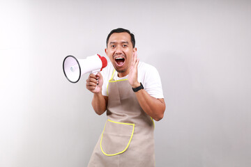 Asian male housekeeper chef cook baker man wear apron hold in hand megaphone scream announces...
