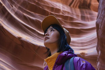 Woman in Prple Jacket and Cap Exploring A Canyon
