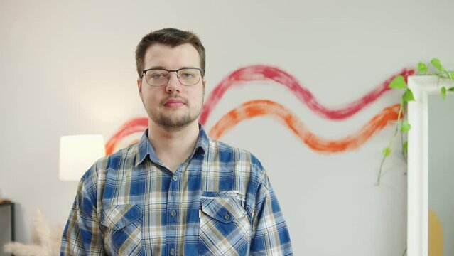 Portrait of male psychologist in eyeglasses standing in his office and looking at camera