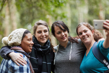 Women, phone and selfie while hiking in nature for fitness, wellness and health with social media. Friends, smartphone and smile on mountain forest for exercise, memory and adventure with happiness