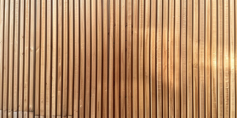 Wooden wall background with vertical slats, texture of natural wood paneling for interior design or backdrop. Wooden paneling wall. 