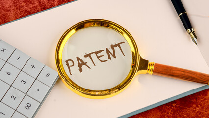 Patent concept. A word PATENT written in the business book of the head with a magnifying glass on...