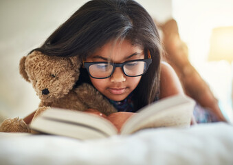 Child, girl and reading book for home learning, education or story with glasses for knowledge and...