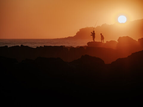 Father and Son Fishing from the Rocks