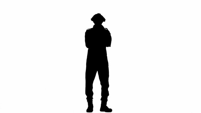 A black silhouette of a man in a overalls folds his arms across his chest and stares confidently into the camera. An unrecognizable man with curly hair poses against a white isolated background.