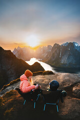 Family picnic in mountains mother and child drinking hot chocolate with thermos sitting in camping chairs travel summer vacations outdoor woman with kid hiking together in Lofoten islands Norway