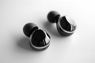 Modern Technology Concept with Black Wireless Earbuds on White Background