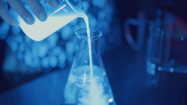 Pouring glowing liquid into beaker in science laboratory