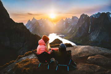 Family picnic in Norway mother and child relaxing in mountains travel vacations outdoor woman with kid in camping chairs enjoying sunset Lofoten islands view Reinebringen hiking adventure trip
