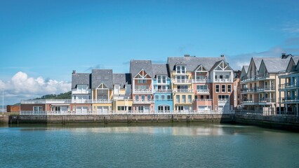 Obraz premium Houses line the shoreline of a picturesque harbor in the town by the water