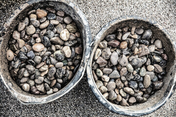 a large pile of pebbles or river gravel in two buckets