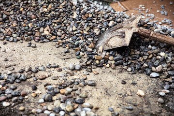 a large pile of pebbles or river gravel with a shovel