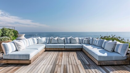 Fototapeta premium A large, light blue and white striped outdoor sofa set on the wooden deck of an oceanfront home in Malibu with panoramic sea views under a clear sky