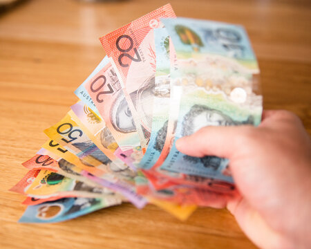 a hand holding Australian cash in bank notes