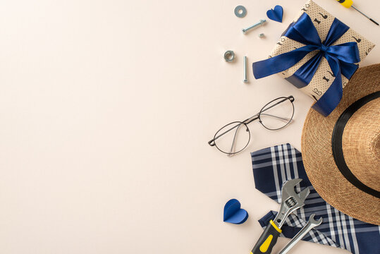 A curated Father's Day setup with stylish hat, glasses, wrapped gift, and tools. Ideal for celebrating dad with a touch of elegance and functionality