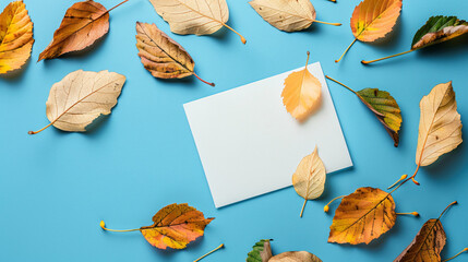 Blank card and autumn leaves on color background