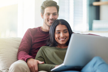 Fototapeta premium Couple, remote work and woman with bonding in home, laptop and working with help and relax on sofa. Freelancer, entrepreneur and girl with man, computer and apartment of editor and writer online