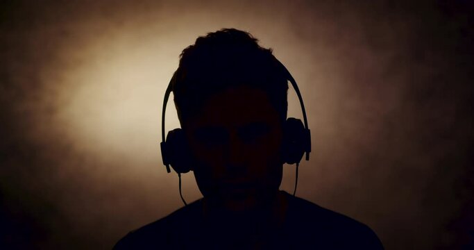 Silhouette of man wearing headphones