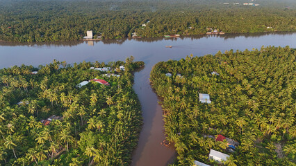 Beautiful aerial view of Mekong Delta countryside, coconut land with vast coconut, nipa palm jungle, riverside house and waterway transport good for Vietnam ecotourism at Ben Tre