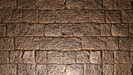 A decorative stone wall illuminated by a spotlight from below.