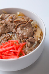 白背景の紅生姜がのった牛丼の写真