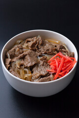 黒背景の紅生姜がのった牛丼の写真