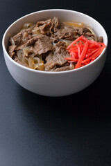黒背景の紅生姜がのった牛丼の写真