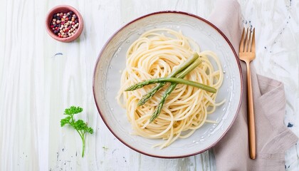 traditional italian spaghetti with asparagus in a herb sauce served as a top view on a nordic design plate