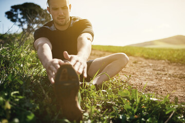 Runner, grass or man stretching legs for training, exercise or fitness workout in countryside...