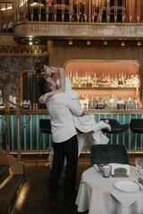 A young couple in wedding looks posing in a stylish loft bar.