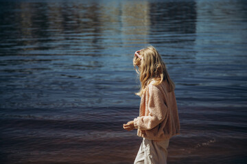 Little girl walking on the river bank, place for text.