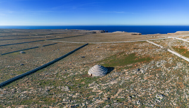 view of the typical stone walls and fields encasing the historic Talayot stone houses on Menorca Island in Spain
