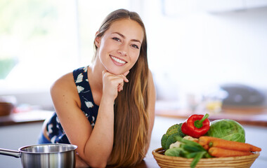 Portrait, happy and woman with vegetables on kitchen counter for health, nutrition and wellness....