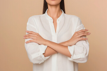 Woman in a white shirt making a stop sign with her hands in a crossed arms pose on a beige background in a closeup portrait