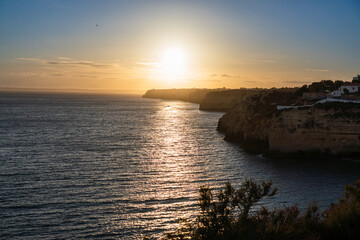 Algar Seco in Carvoeiro. Beautiful Golden Sandstone Rock Formation in Algarve with Atlantic Ocean in the Distance. Rocks, rocky shore, yellow rocks, coquina, beautiful coastline. Sunset