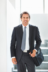 Happy, businessman and walking down stairs in portrait with laptop bag in office for travel. Smile, male person or entrepreneur with luggage for corporate trip or commute to conference or convention