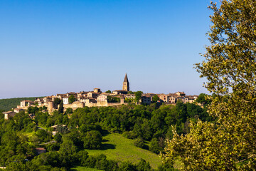 Fototapeta premium Village médiéval de Puycelsi, au sommet de son plateau rocheux et protégé par ses remparts du XIVe siècle, dominant la Forêt de la Grésigne