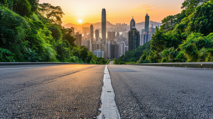 Fototapeta premium An empty paved summer road to the metropolis, stretching into the distance with clear skies above and the city skyline visible on the horizon.