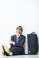 Sleeping, luggage and man with mask in airport for business trip, international flight or...