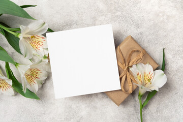 Square paper thank you or birthday card mockup with gift box and flowers, copy space