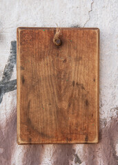 Old wooden blank signboard on the aged cement wall background