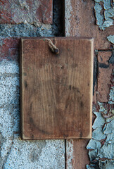 Old wooden blank signboard on the aged cement wall background