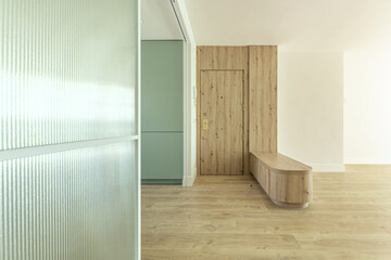 Front image of a modern design open kitchen with pastel green furniture, with an extendable glass...