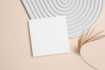 Square paper card mockup, blank invitation, greeting or flyer card with copy space on beige background