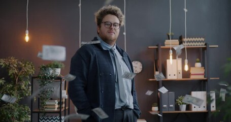 Portrait of wealthy businessman throwing dollar banknotes looking at money standing in dark office in evening. Finance and business concept. - Powered by Adobe