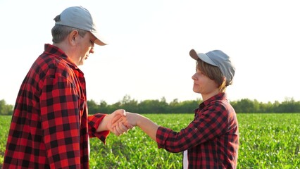 Man and woman agronomist work as team at corn field use digital tablet pc closeup. Farmer...