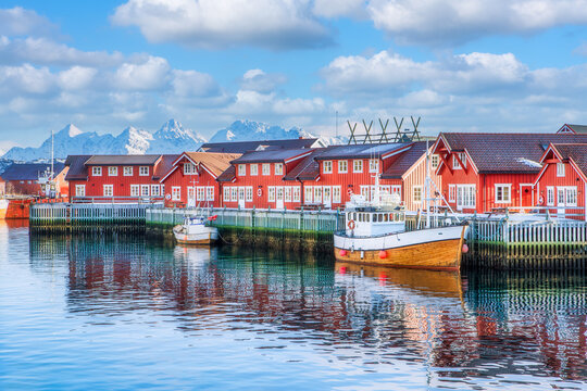 A sailing boat anchored in front of the wooden Rorbu cabins in the Lofoten Islands fishing village, Svolvaer, Lofoten islands, Norway