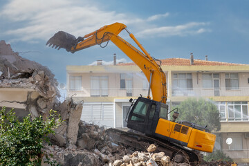 Building demolition excavator with long mechanical arm. Destruction of a house. Heavy machinery,...
