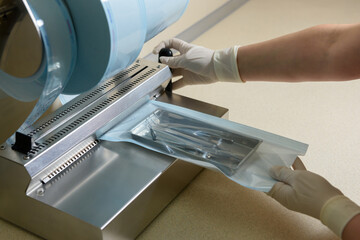 Sterilization of dental medical instruments. Dental assistant packs dental equipment into plastic...